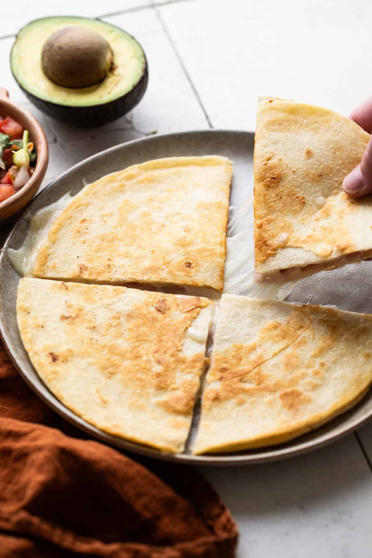 A sincronizada sliced into 4 triangles on a plate.