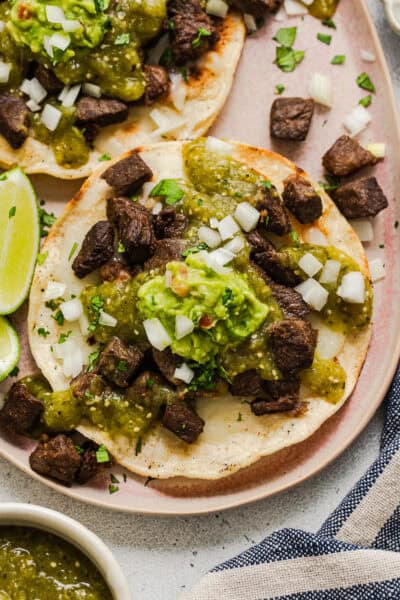 A vampiro taco topped with carne asada, salsa verde, and guacamole.