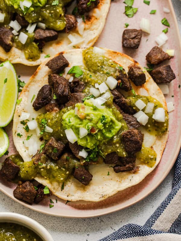 A vampiro taco topped with carne asada, salsa verde, and guacamole.