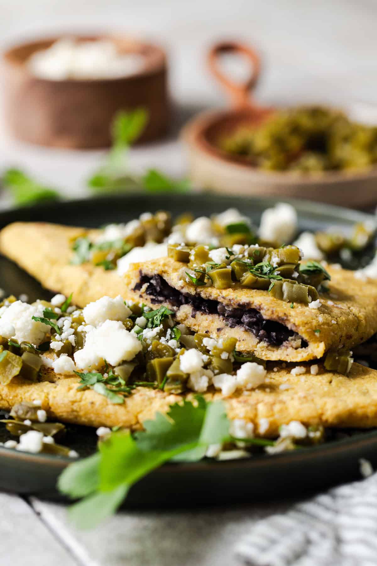 A tlacoyo sliced in half to see the cross section and the bean filling.
