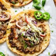 Chicken smash tacos on a platter topped with cilantro lime slaw.