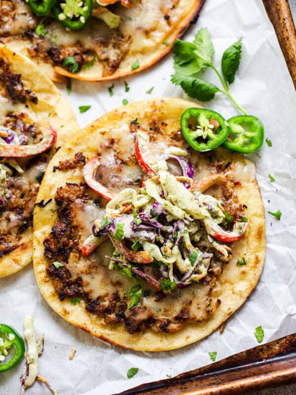 Chicken smash tacos on a platter topped with cilantro lime slaw.
