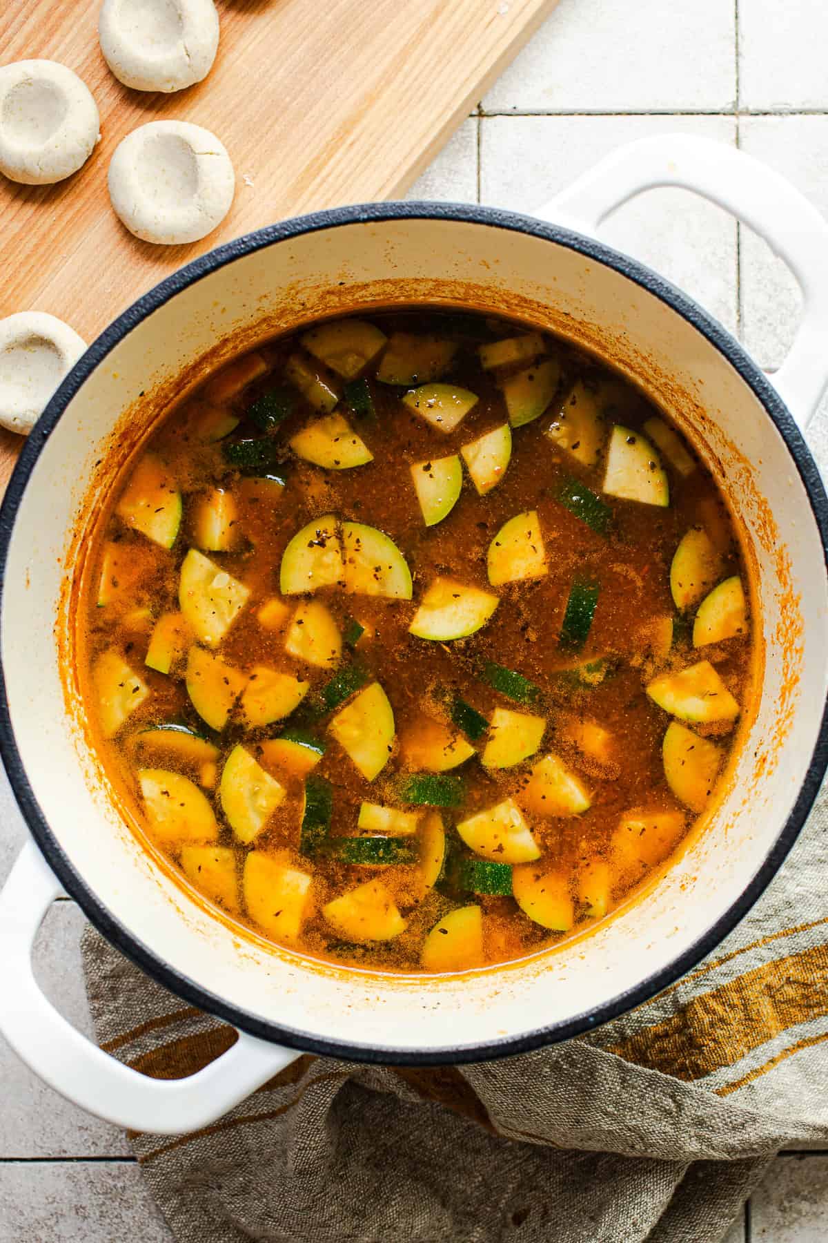 Vegetable soup simmering in a pot before the chochoyotes are added.