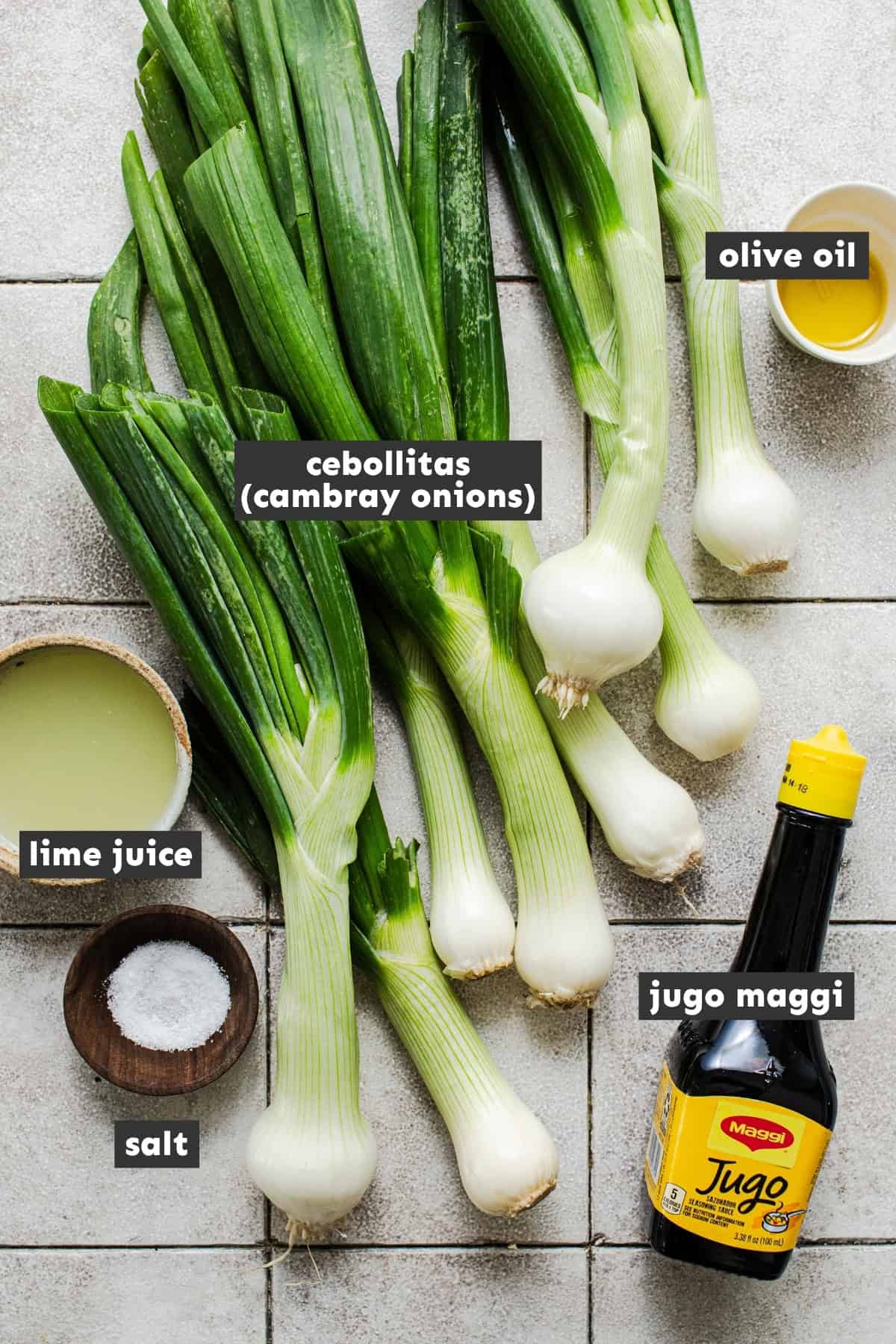 Ingredients for cebollitas asadas including cambray onions, lime, salt, and Jugo Maggi.