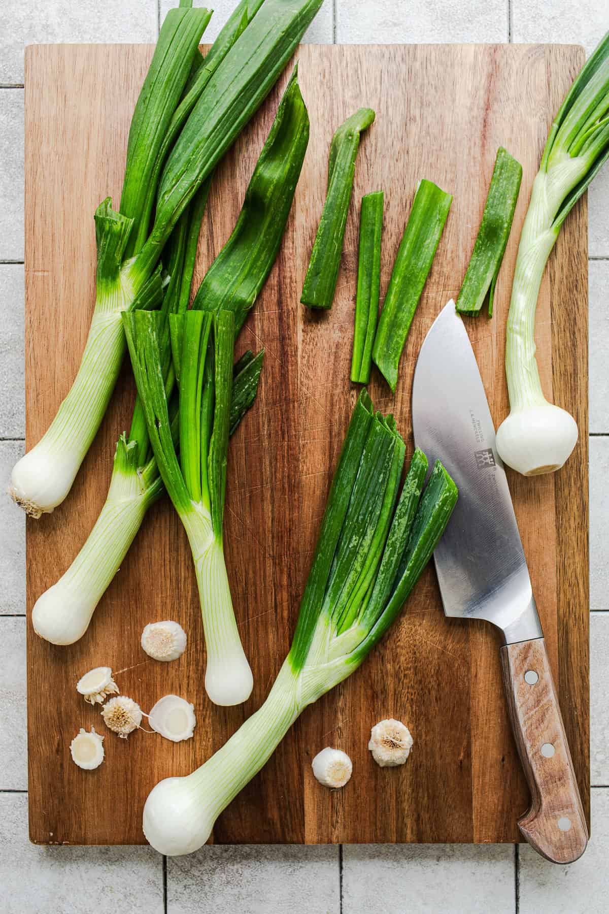 Trimmed cambray onions on a cutting board ready to make cebollitas asadas.