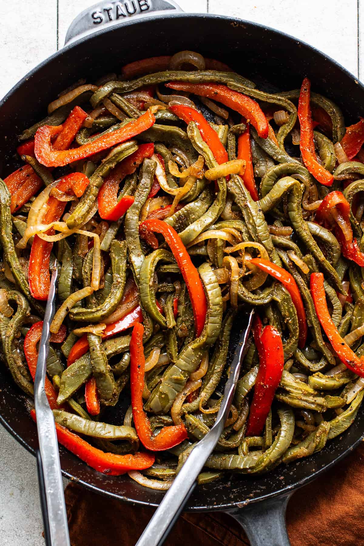 Sauteed peppers, onions, and nopales in a skillet for nopales tacos.