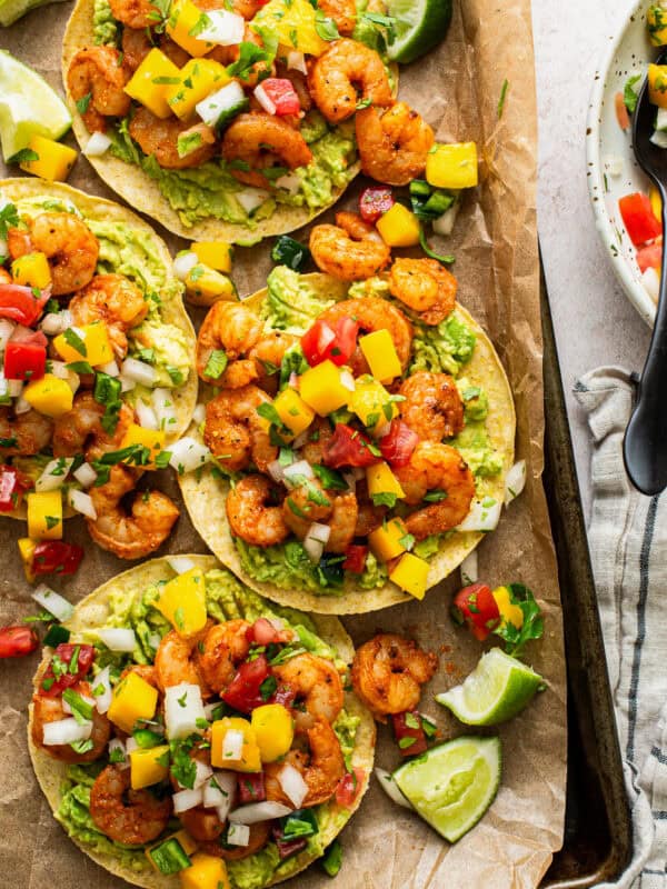 Shrimp tostadas topped with avocado and mango pico de gallo.