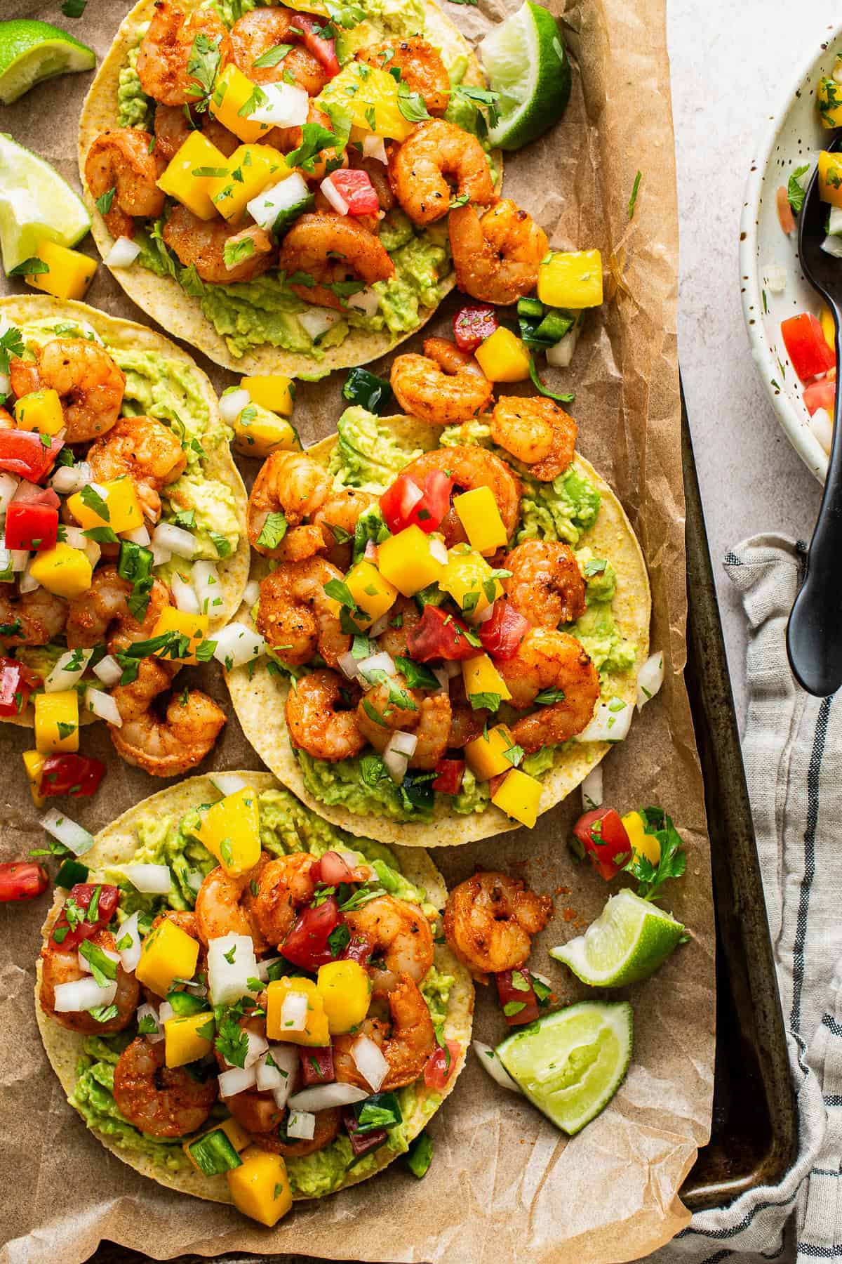 Shrimp tostadas topped with avocado and mango pico de gallo.