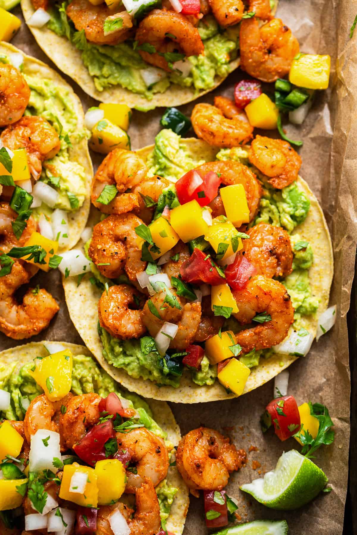 Shrimp tostadas topped with avocado and mango pico de gallo.