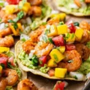 Shrimp tostadas topped with mango pico de gallo on smashed avocado.
