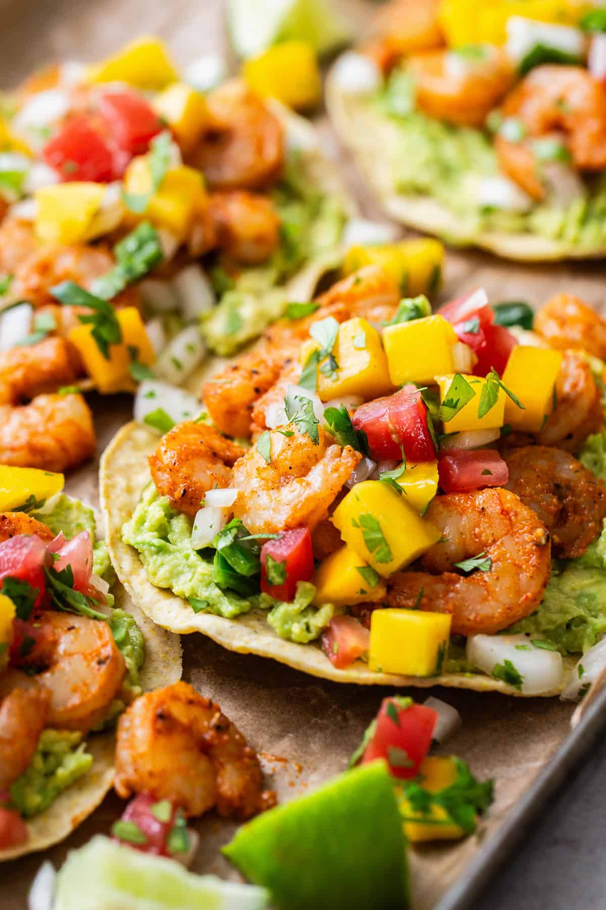 Shrimp tostadas topped with mango pico de gallo on smashed avocado.