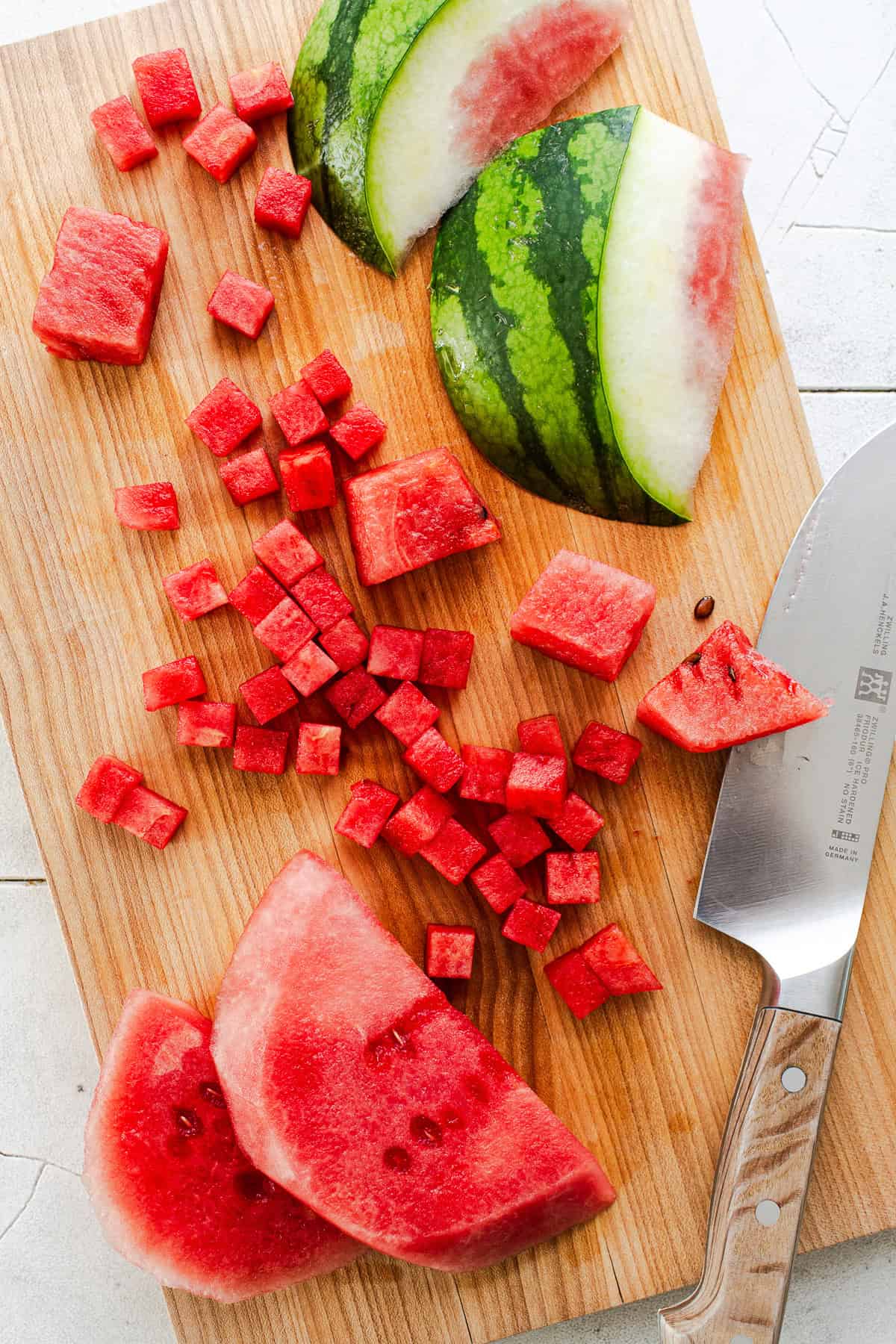 Chopped watermelon on a cutting board for making watermelon salsa.