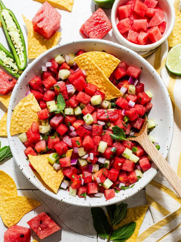 Watermelon salsa with mint and cucumber in a bowl with tortilla chips for eating.