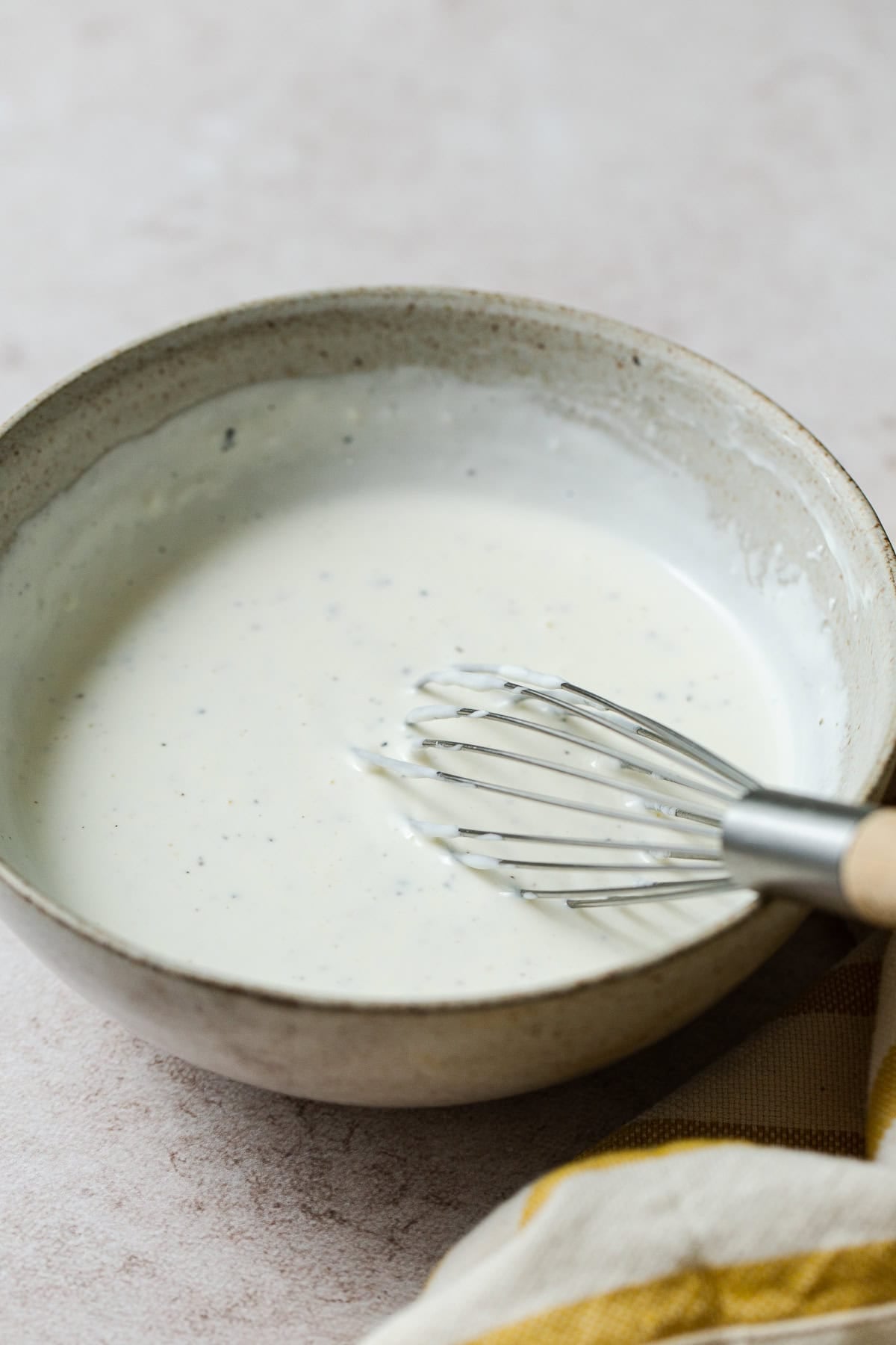Whisking the creamy dressing for Mexican tuna salad with mayo, sour cream, Mexican crema, lime juice, and pickle jalapeño brine.
