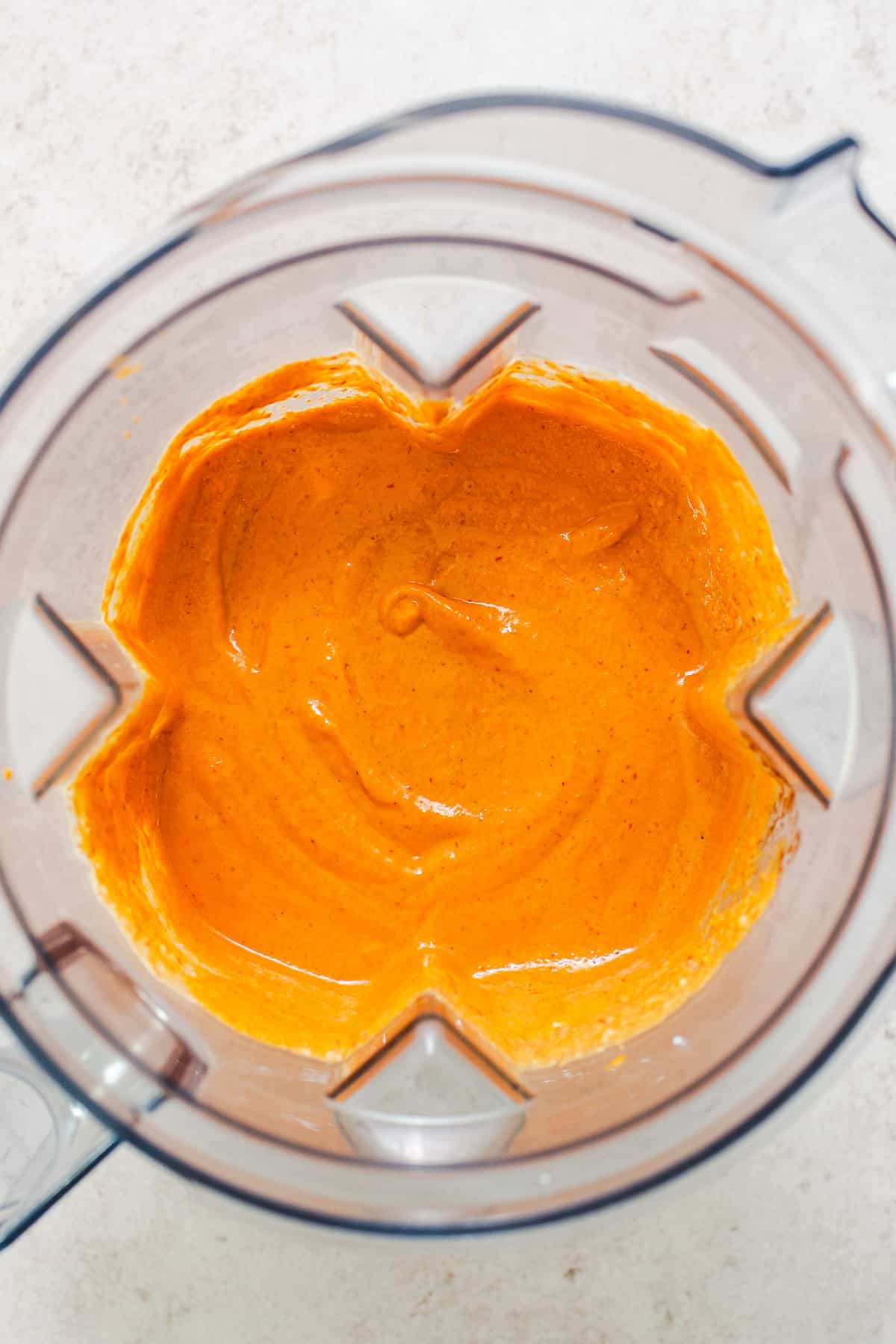 Smooth orange chipotle pasta sauce blended in a blender.