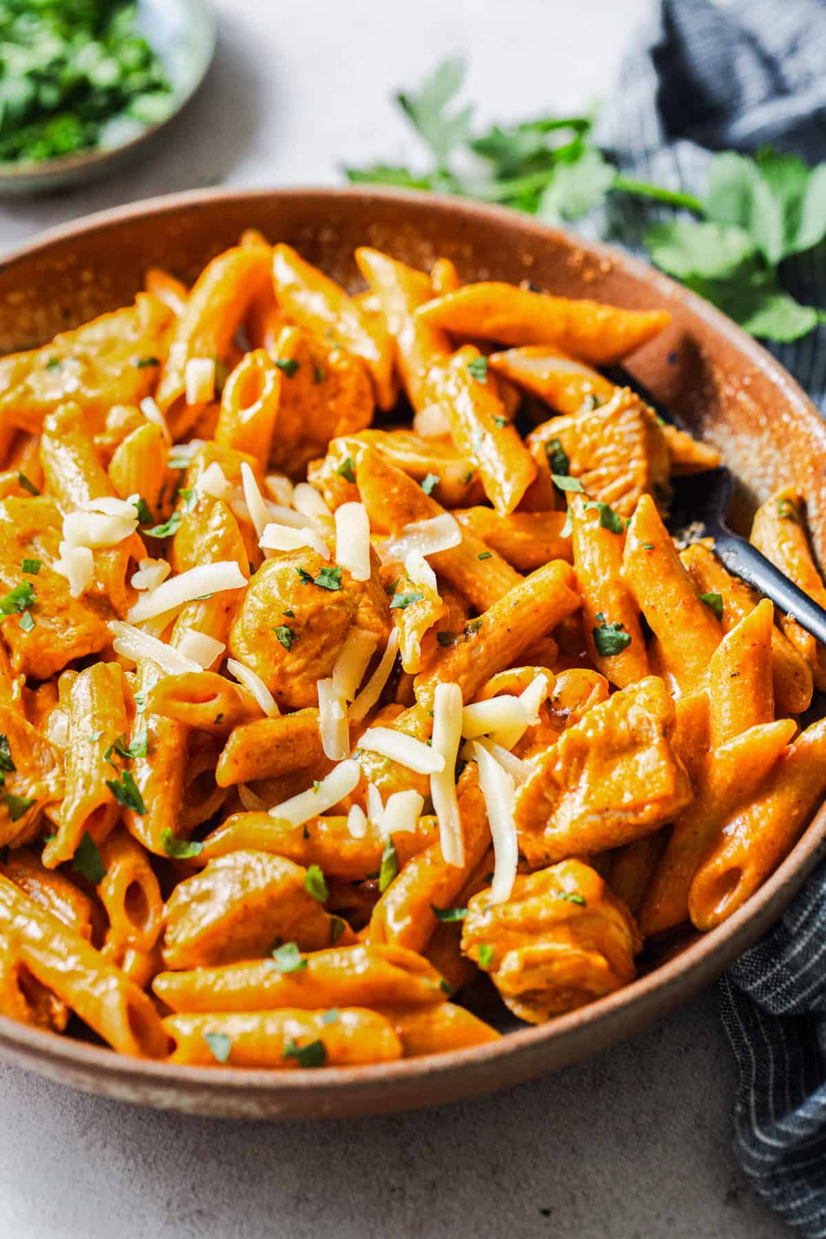 Creamy chipotle chicken pasta in a bowl garnished with chopped cilantro.