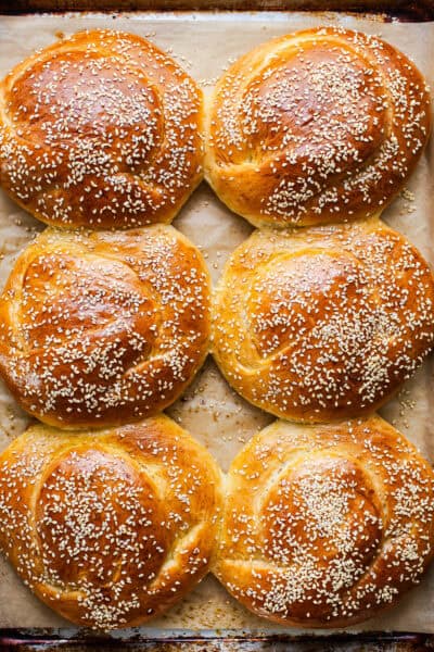 Golden baked cemita buns (mexican sesame bread) on a baking sheet