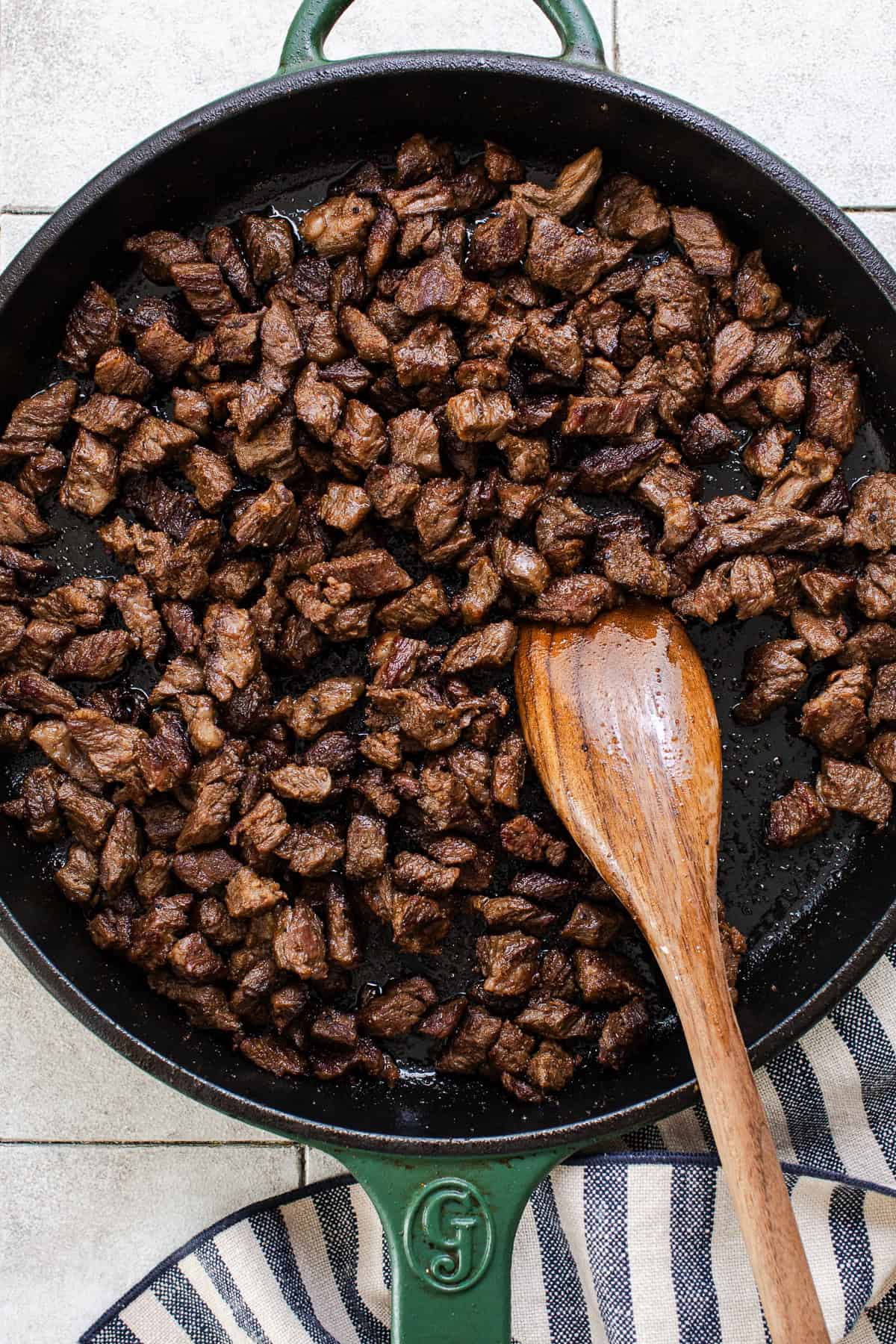 Carne asada searing in a skillet for papas locas.