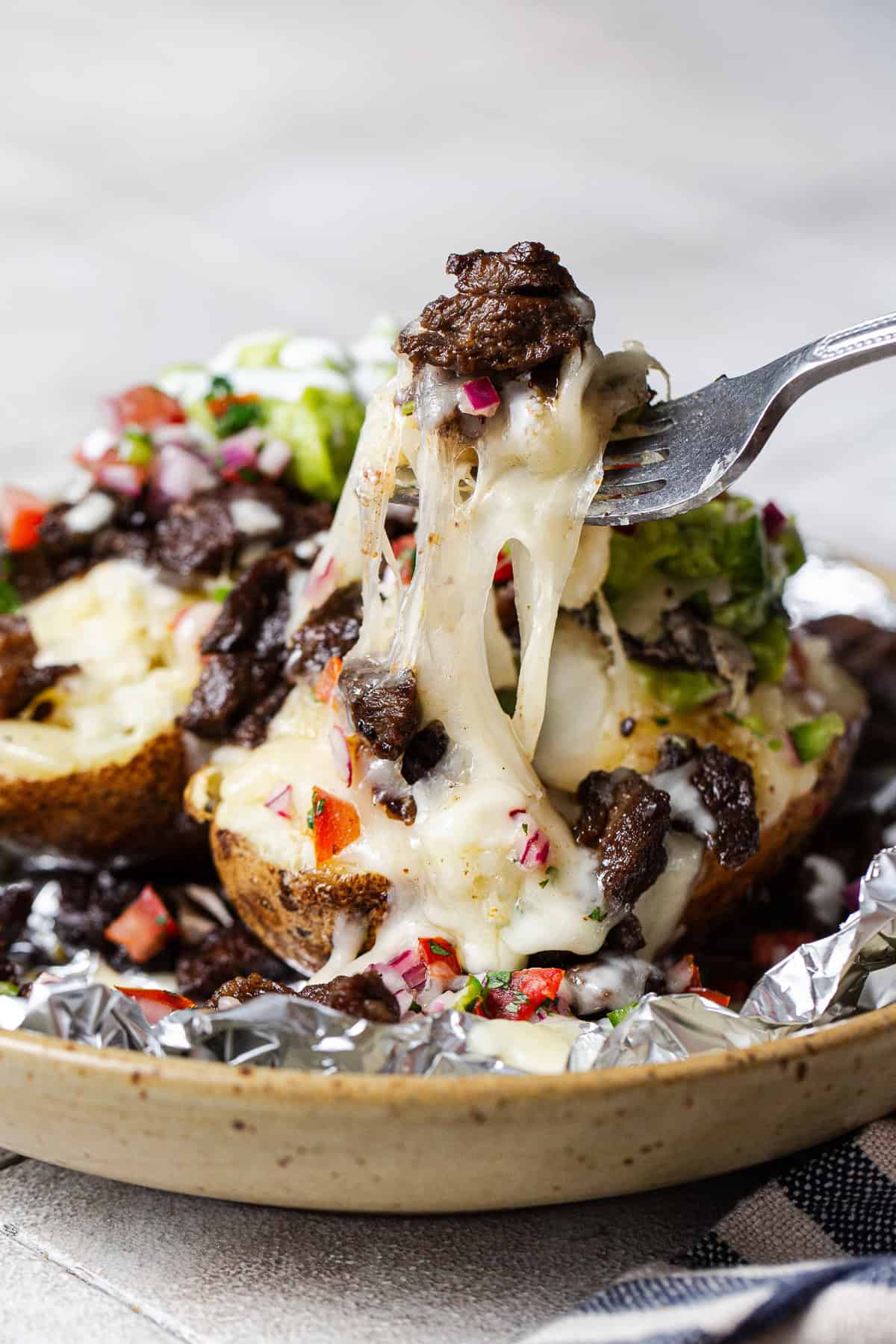 Cheese pull from a carne asada papas locas baked potato.