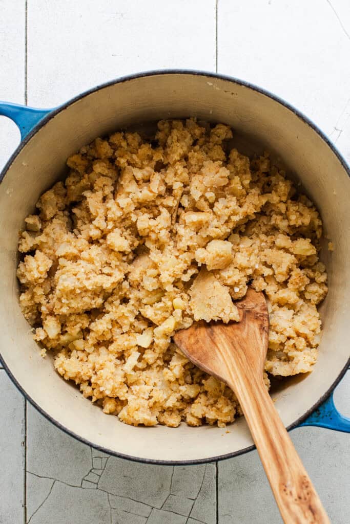 The seasoned mashed potato filling for potato tacos in a pot.