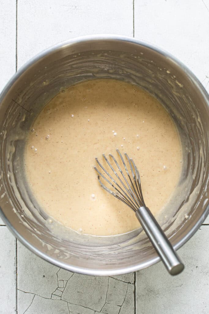 Tres leches cupcake batter in a mixing bowl with a whisk.